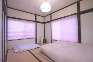 a bedroom with two windows and a bed in it at 水龍Suiryu in Fujisawa