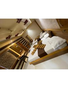 two beds in a small room with a staircase at Hotel Sukhnath, Somnath in Somnath