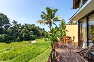 a balcony with chairs and a view of a field at Ubud Green Resort Villas Powered by Archipelago in Ubud
