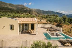 a house with a swimming pool and mountains in the background at Uberina - Olea Di Assos Villas in Asos