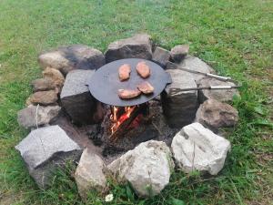 a grill with some food on top of rocks at Šťastná Maringotka 