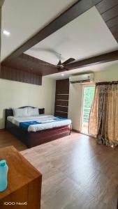 a bedroom with a bed and a large window at Hitech Shilparamam Guest House in Hyderabad