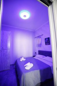 Habitación púrpura con 2 toallas blancas en una cama en MG House_2, en Nápoles 10 fotos más