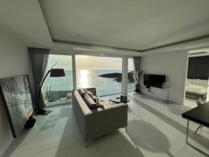 sala de estar con sofá y vistas al océano en The Beach Residence, en Koh Samui 