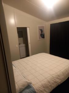 a bedroom with a white bed in a room at Rimu in Ohakune