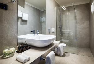 a bathroom with a white sink and a shower at Boutique & Design Hotel Navis - Small Luxury Hotels of the World in Opatija