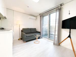 a living room with a couch and a large window at W Premium Guesthouse Incheon airport in Incheon
