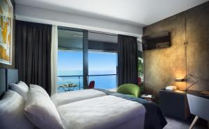 a hotel room with a bed and a large window at Boutique & Design Hotel Navis - Small Luxury Hotels of the World in Opatija