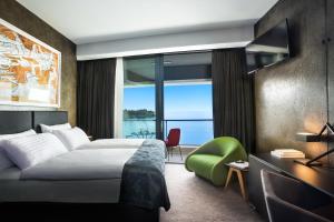 a hotel room with a bed and a large window at Boutique & Design Hotel Navis - Small Luxury Hotels of the World in Opatija