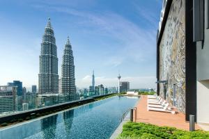 a swimming pool on the roof of a building with tall buildings at Ascott Star KLCC in Kuala Lumpur