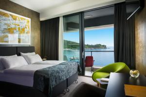 a hotel room with a bed and a view of the water at Boutique & Design Hotel Navis - Small Luxury Hotels of the World in Opatija