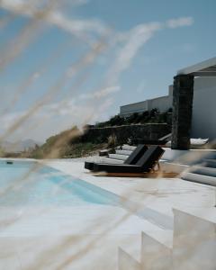 una piscina con tumbonas en la azotea de un edificio en Pili Pala Suites en Episkopianá
