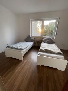 2 camas en una habitación con ventana en Ferien & Monteurwohnung in Bohmte-Hunteburg, en Bohmte
