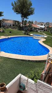 una gran piscina azul en un patio en Casa adosada residencial en Benalmádena