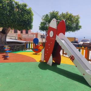 een speeltuin met een glijbaan in een park bij Candela's House in Barranco Hondo