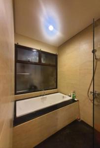 a bathroom with a bath tub and a window at Vimalla Hills Villa Resort Exclusive Villa Puncak in Gadok 1