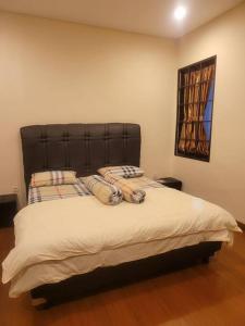 a bed with a black headboard in a bedroom at Vimalla Hills Villa Resort Exclusive Villa Puncak in Gadok 1