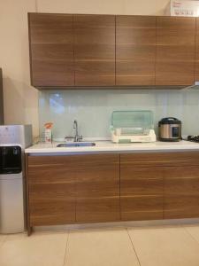 a kitchen with wooden cabinets and a sink and a refrigerator at Vimalla Hills Villa Resort Exclusive Villa Puncak in Gadok 1