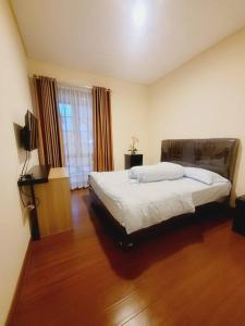 a bedroom with a large bed and a television at Vimalla Hills Villa Resort Exclusive Villa Puncak in Gadok 1