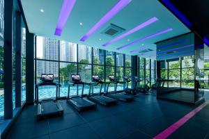 - une salle de sport avec une rangée de tapis de course dans un bâtiment dans l'établissement Ascott Star KLCC, à Kuala Lumpur