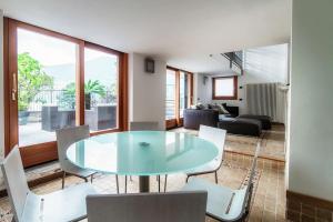 een woonkamer met een glazen tafel en stoelen bij Sun Luxury Apartment with Swimming Pool - Blevio in Blevio