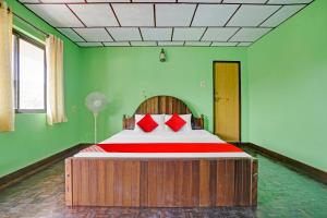 1 dormitorio con 1 cama grande con almohadas rojas en Flagship Green Fort Thekkady, en Thekkady