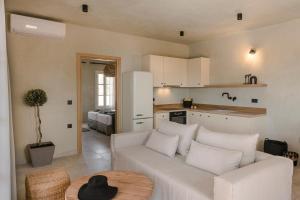 a living room with a white couch and a table at Uberina - Olea Di Assos Villas in Asos