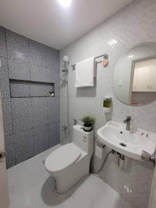 ein weißes Bad mit einem WC und einem Waschbecken in der Unterkunft Cozy Transient house in Calapan City. in Calapan
