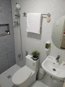 ein Badezimmer mit einem weißen WC und einem Waschbecken in der Unterkunft Cozy Transient house in Calapan City. in Calapan