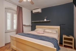 a bedroom with a bed with a blue wall at Apartment San Pietro in Cavtat