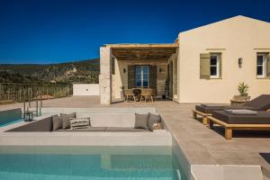 a house with a swimming pool next to a house at Uberina - Olea Di Assos Villas in Asos