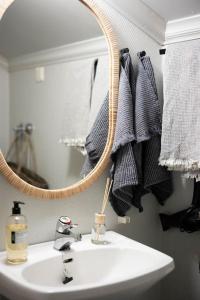 a bathroom with a sink and a mirror and towels at Kotoisa asunto Museon pihapiirissä Rautalammilla in Rautalampi