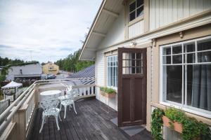 una casa con balcón con mesa y sillas en Kotoisa asunto Museon pihapiirissä Rautalammilla, en Rautalampi