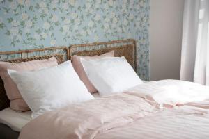 a bed with white sheets and pillows in a bedroom at Kotoisa asunto Museon pihapiirissä Rautalammilla in Rautalampi