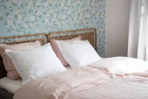 Una cama con sábanas blancas y almohadas en un dormitorio en Kotoisa asunto Museon pihapiirissä Rautalammilla, en Rautalampi