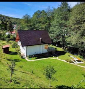 ein kleines Haus inmitten eines grünen Feldes in der Unterkunft Orange House in Trnovo