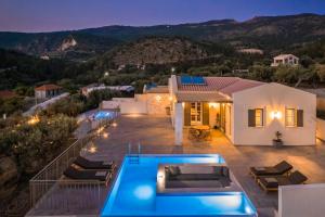 a villa with a swimming pool at night at Uberina - Olea Di Assos Villas in Asos