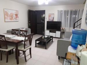 a living room with a couch and a table and a tv at Bayswater subdivision guest house .. in Agus
