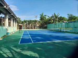 una pista de tenis con una red en Bayswater subdivision guest house .. en Agus