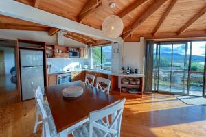 een keuken en eetkamer met een tafel en stoelen bij HEXAGON BEACH HOUSE Binalong Bay of Fires Views in Binalong Bay