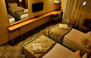 una camera d'albergo con due letti e uno specchio di Adranos Hotel a Bursa