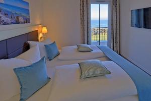 a hotel room with two beds and a balcony at Aparthotel Waterkant Suites - Fewos am Meer mit SPA in Börgerende-Rethwisch