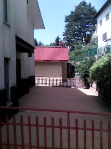 une clôture devant un bâtiment avec un toit rouge dans l'établissement Appartamentino, à Camigliatello Silano