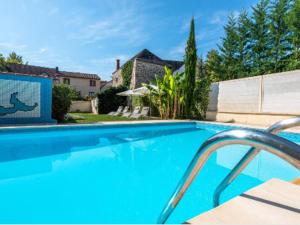 a large blue swimming pool in front of a house at studio du parc piscine in Souillac