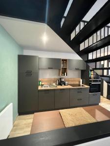 a large kitchen with gray cabinets and a stove at La Manufacture du Sable in Berck-sur-Mer