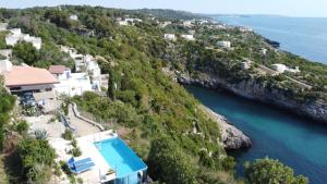 an aerial view of a house on a hill next to the water at VILLE GIRASOLI "VILLA NELLA BAIA" with PRIVATE SWIMMING POOL in Tricase