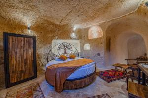 a bedroom with a bed in a cave style room at Ages in Cappadocia in Uçhisar
