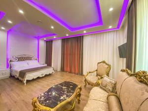 ein Schlafzimmer mit einem Bett und einer lila Decke in der Unterkunft Red Hill Hotel in Tirana