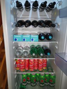 an open refrigerator filled with bottles and cans of soda at Apartment Sončni Mokec in Rečica ob Savinji