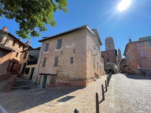 a large brick building on a cobblestone street at La voûte du 26 in Albi